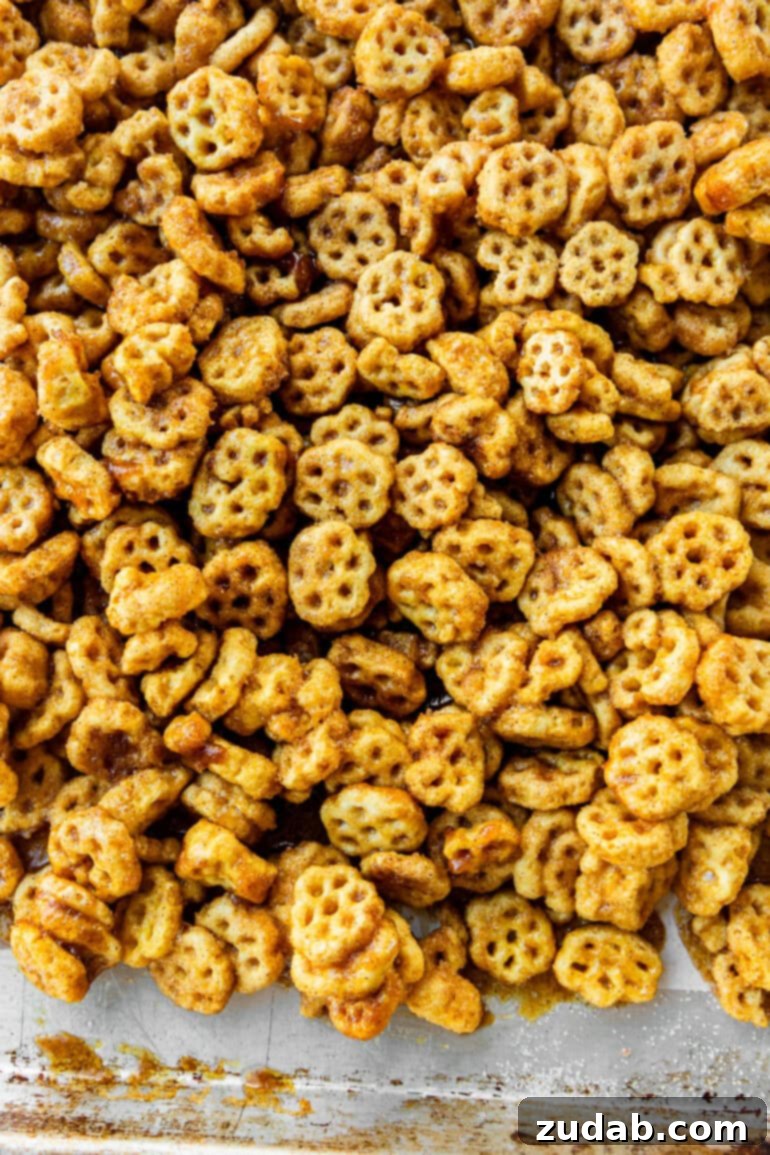Easy No-Bake Churro Crunch 3 a photo of a baking sheet covered in caramel and cinnamon sugar coated honeycomb cereal