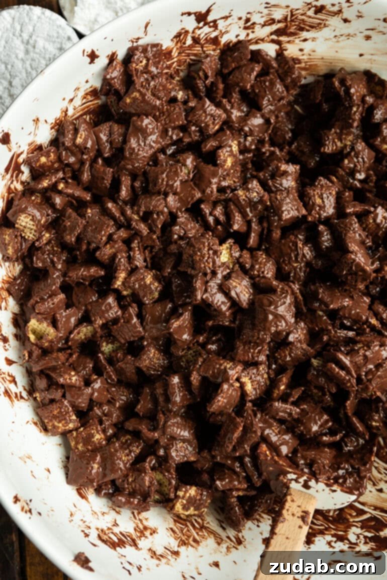 Decadent Dark Chocolate Peanut Butter Muddy Buddies 6 Pouring melted chocolate mixture over Chex cereal in a large bowl.