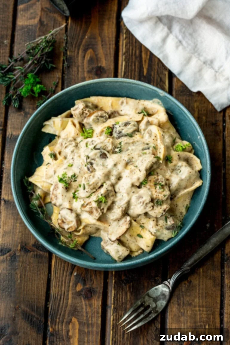 Effortless Slow Cooker Beef Stroganoff 9 Bowl of beef stroganoff topped with herbs