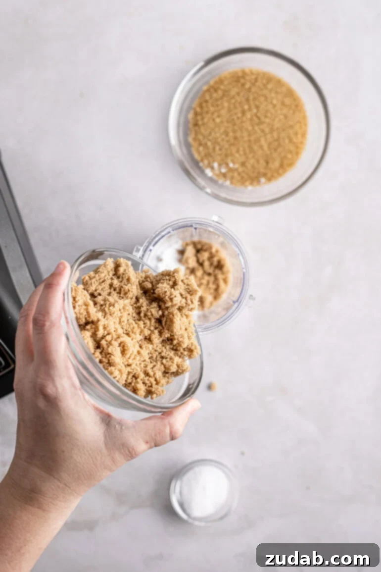 Signature Caramel Popcorn Blend 6 Brown sugar being poured into a small bowl full of white sugar.