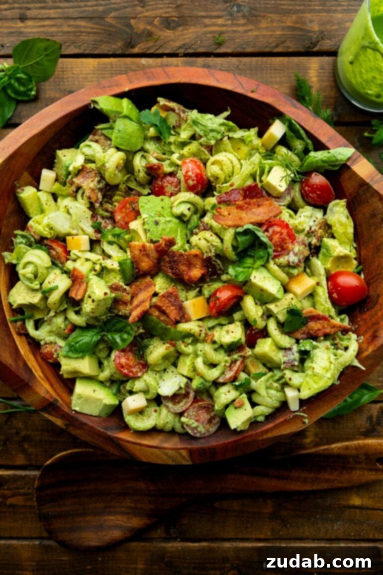 BLT Pasta Perfection 2 A large wooden serving bowl filled with creamy BLT pasta salad, showcasing the crispy bacon, juicy tomatoes, and fun-shaped pasta.