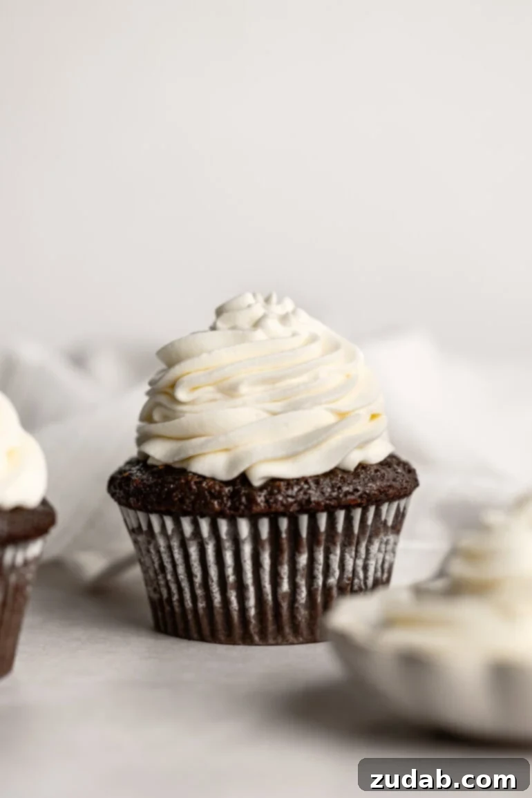 Light and Fluffy Cream Cheese Frosting 2 A chocolate cupcake lavishly topped with a piped swirl of light and fluffy whipped cream cream cheese frosting.