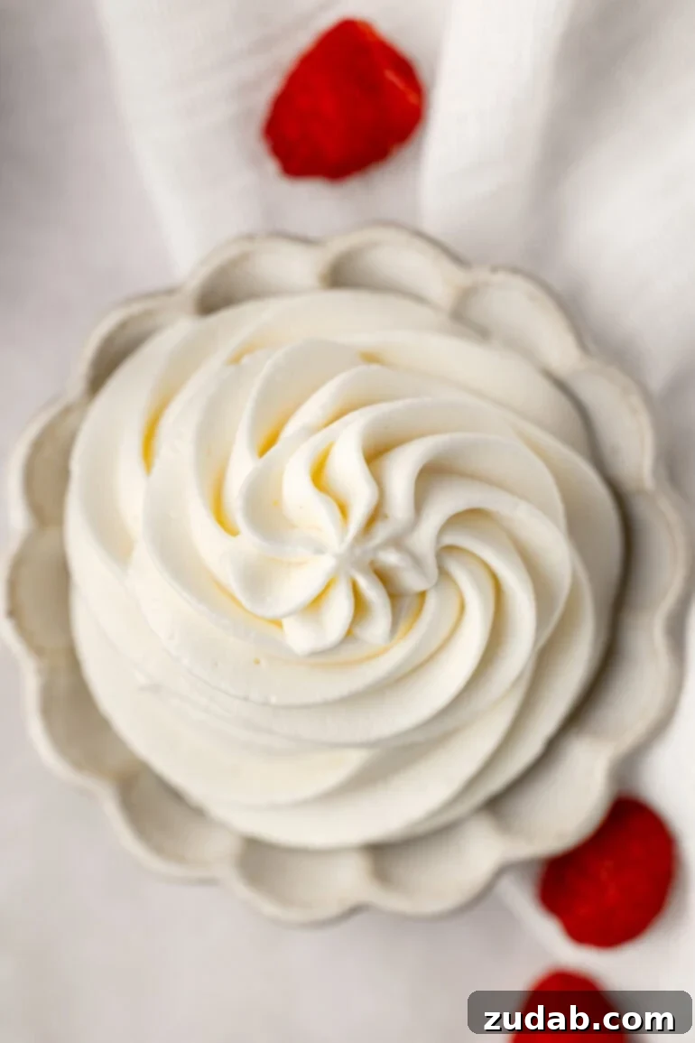 Light and Fluffy Cream Cheese Frosting 12 An overhead view of a small bowl filled with beautifully piped whipped cream cream cheese frosting, showcasing its light and airy texture.