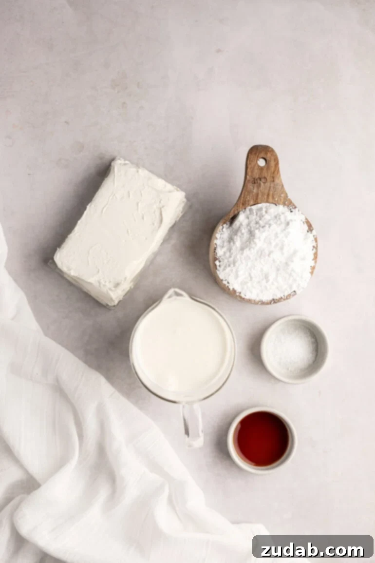 Light and Fluffy Cream Cheese Frosting 3 A collection of small bowls, each containing one of the five simple ingredients needed for whipped cream cream cheese frosting: heavy cream, cream cheese, powdered sugar, salt, and vanilla extract.