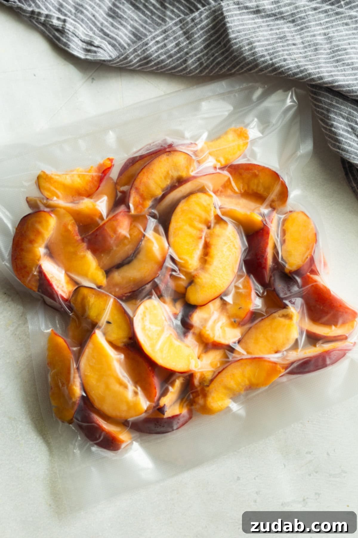 Freeze Peaches Perfectly Every Time 2 Vacuum-sealed freezer bag filled with sliced peaches, ready to be stored for long-term freezing.