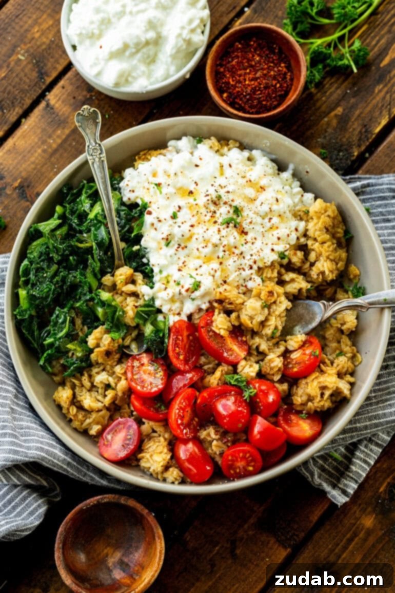 7 Minute High Protein Savory Cottage Cheese Oats 2 a photo of a bowl of crispy oats mixed with cherry tomatoes, cottage cheese, chopped kale and minced herbs