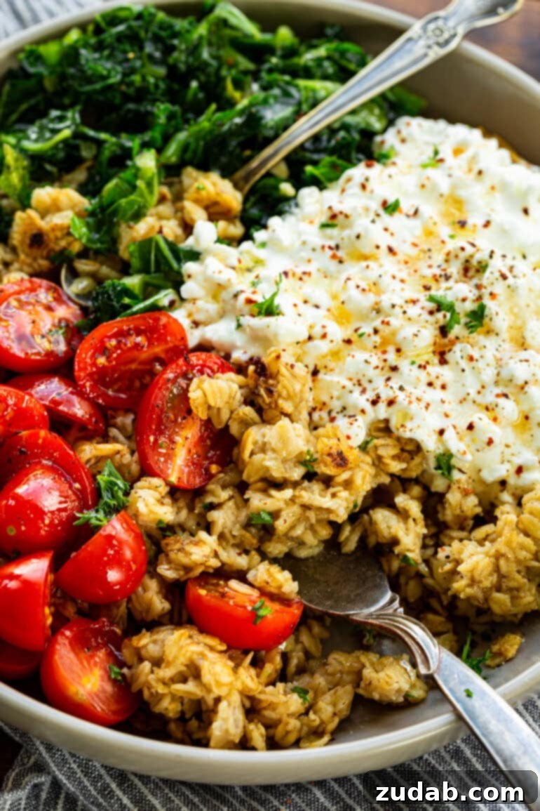 7 Minute High Protein Savory Cottage Cheese Oats 3 a photo of a savory bowl of oatmeal mixed with cottage cheese, halved cherry tomatoes, chopped kale and seasoned cottage cheese