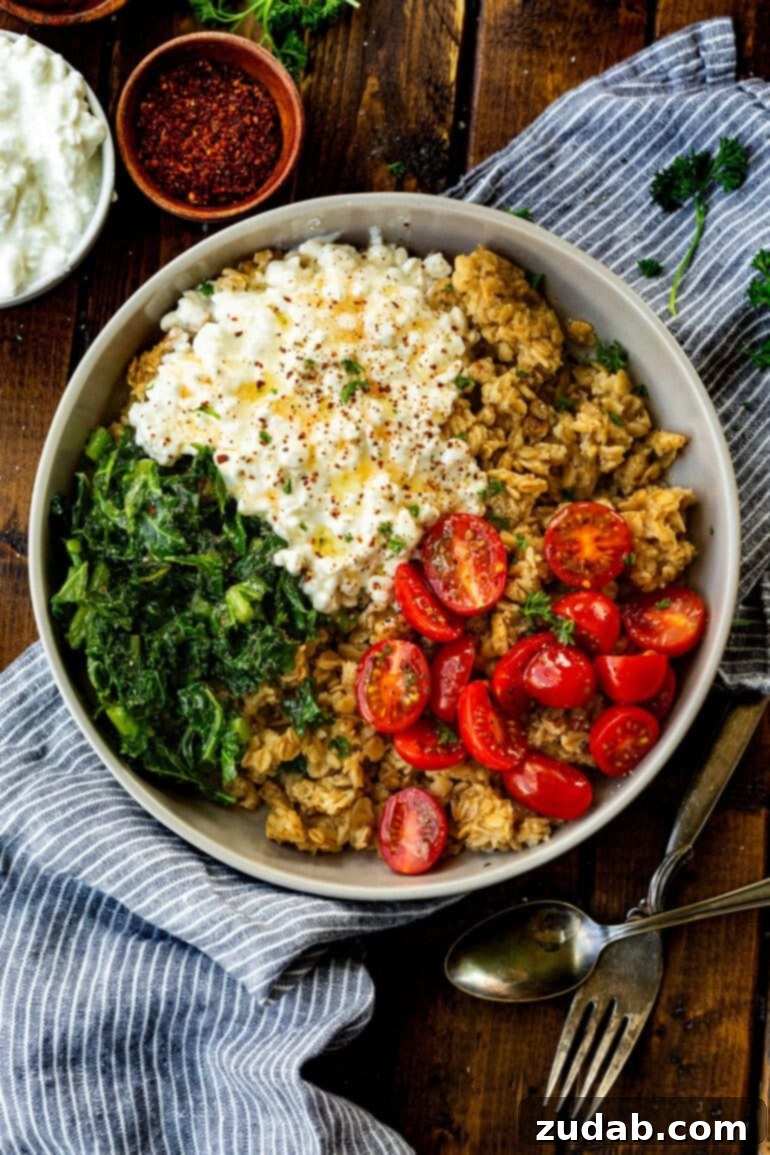 7 Minute High Protein Savory Cottage Cheese Oats 8 a photo of a savory oatmeal breakfast bowl including crispy golden oats, tomatoes, kale and cottage cheese