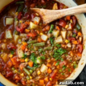 Quick and Easy Ground Beef Vegetable Soup 9 a large bot of ground beef vegetable soup topped with minced fresh parsley with a wooden spoon in the bowl