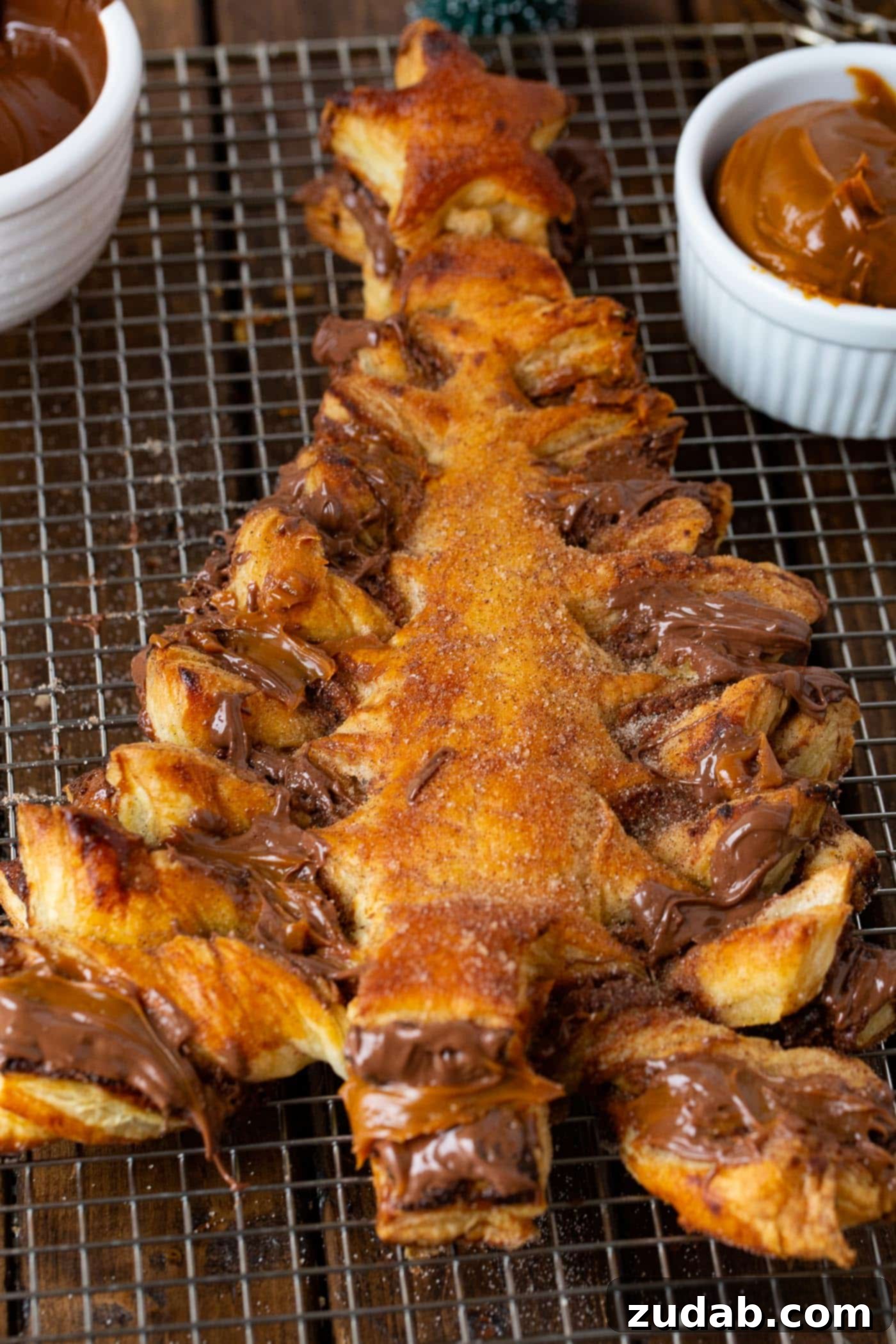 Golden Nutella Dulce de Leche Christmas Tree A perfectly baked, golden Nutella and Dulce de Leche Christmas tree resting on a cooling rack, ready to be enjoyed.