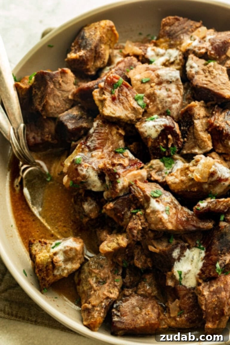 Succulent Slow Cooker Garlic Butter Steak Bites 4 a large bowl of juice steak tips soaked in garlic butter and topped with fresh parsley