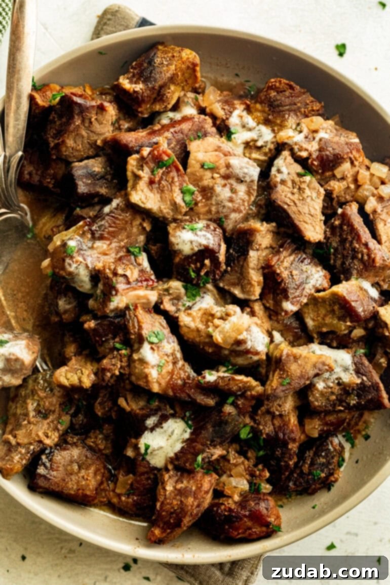 Succulent Slow Cooker Garlic Butter Steak Bites 5 juicy steak bites coated in garlic butter mixed with diced onions and sprinkled with chopped fresh parsley