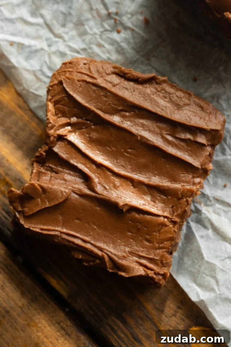 Classic Cafeteria Frosted Brownies 5 Beautifully cut homemade lunch lady brownies with a rustic layer of chocolate frosting, arranged in perfect squares on parchment paper, ready to be savored.
