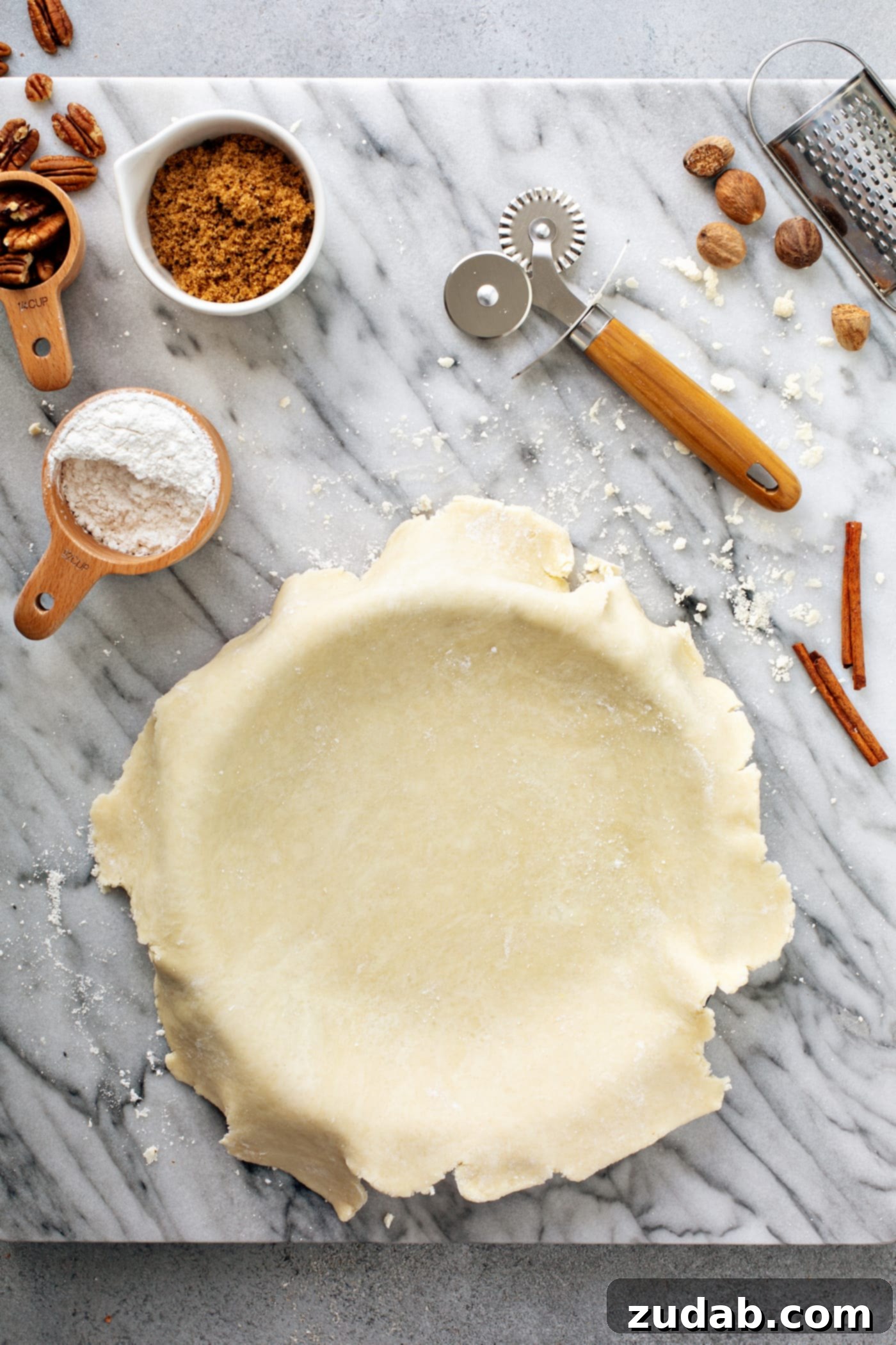 My Go-To Flaky All-Butter Pie Crust 9 A photo of an uncooked pie crust that hasn't been trimmed yet layed on top of a pie tin.