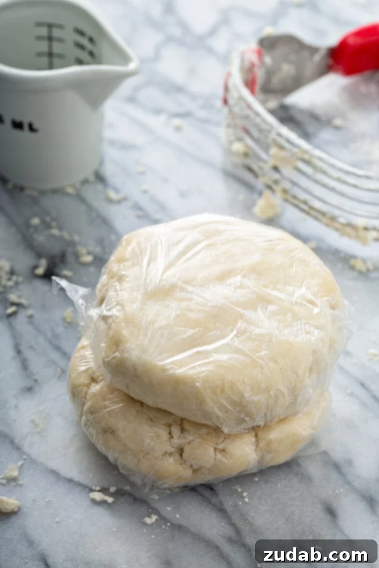 My Go-To Flaky All-Butter Pie Crust 6 Two balls of pastry dough wrapped in plastic wrap. A pastry blender is in the background.