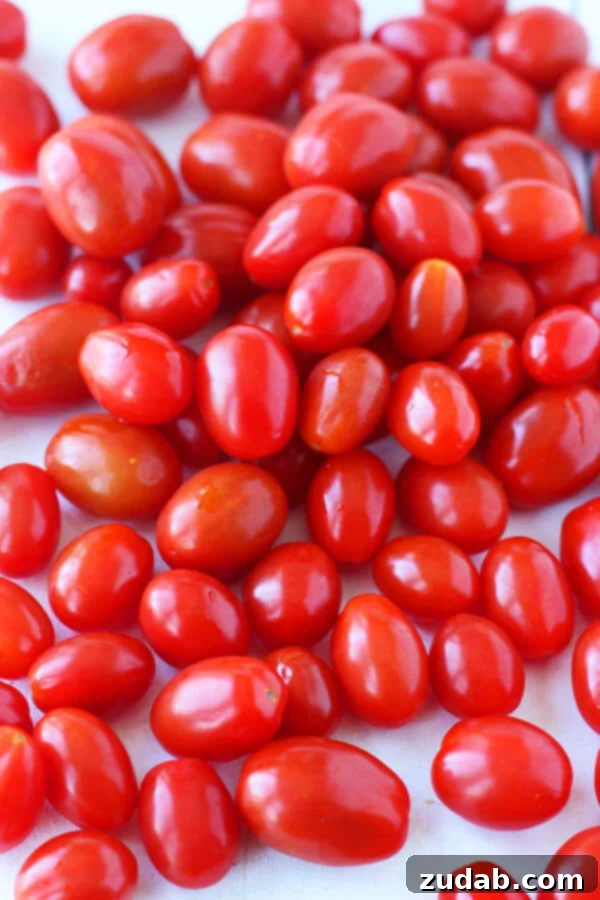 This 20 Minute Cherry Tomato and Basil Angel Hair Pasta comes together in a jiffy, and will satisfy the whole family, even the kids! a photo of a pile of grape tomatoes