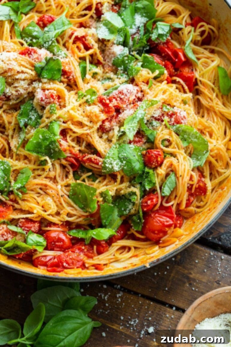 Quick and Easy 20-Minute Tomato Basil Angel Hair Pasta 9 a photo of a large pot full of sauteed grape tomatoes and fresh basil leaves tossed with cooked angel hair pasta