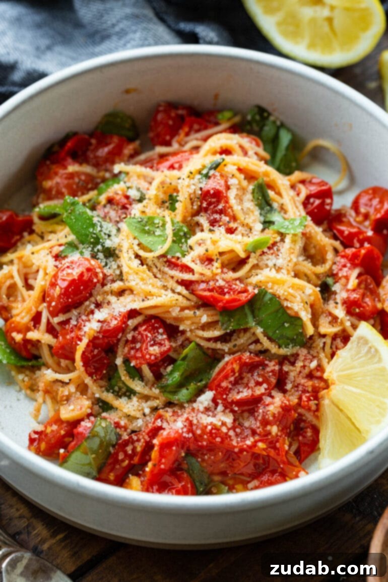Quick and Easy 20-Minute Tomato Basil Angel Hair Pasta 10 a photo of a bowl of angel hair pasta tossed with cooked grape tomatoes, fresh basil leaves and topped with parmesan cheese.