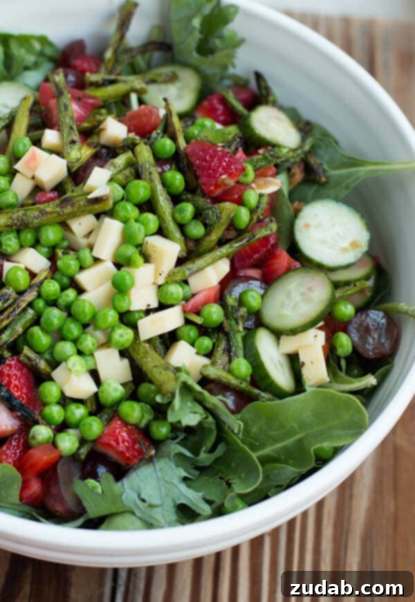 Pomegranate Raspberry Salad with Fresh Ingredients A close-up of the delicious pomegranate raspberry dressing salad, showcasing fresh greens, colorful fruits, and crunchy almonds.