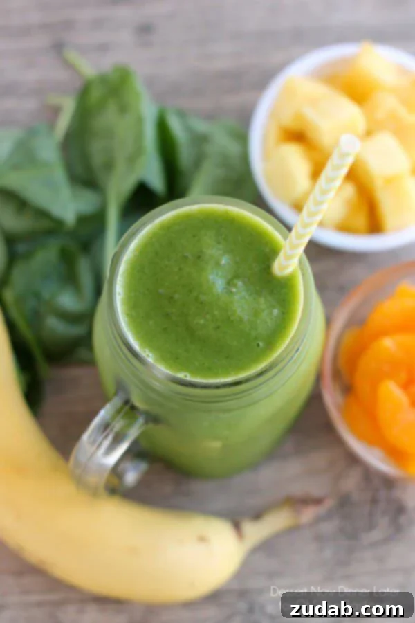 Delicious and Nutritious Green Smoothie for Energy A glass of Pineapple Orange Banana Green Smoothie, showcasing its refreshing texture and inviting color.