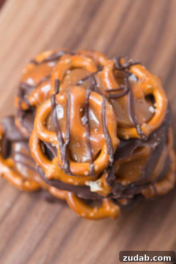 Kid-Friendly Salted Caramel Pretzel Snaps A child's hands carefully sprinkling sea salt over a tray of freshly made salted caramel pretzel snaps, highlighting the family-friendly aspect of the recipe.