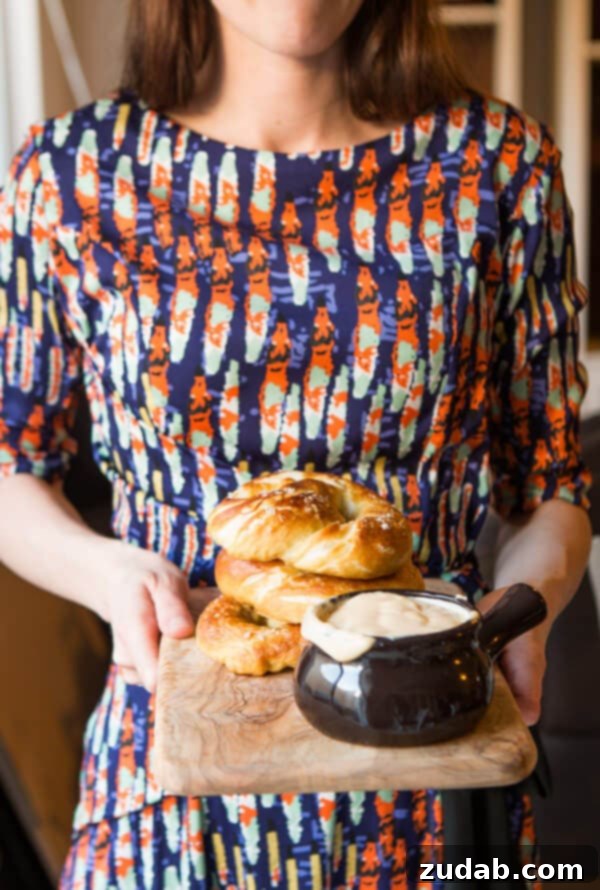 Holding homemade soft pretzels A close-up of hands holding two soft pretzels with cheese sauce, a perfect snack