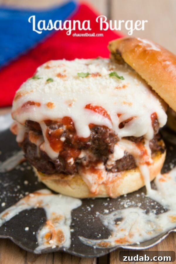 Ricotta, sauce, and mozzarella layered on italian beef for Lasagna burgers! Bring on summer! ohsweetbasil.com Close-up of a stacked lasagna burger, showcasing the melted mozzarella, rich sauce, and creamy ricotta between two slices of seasoned beef, ready to be enjoyed.
