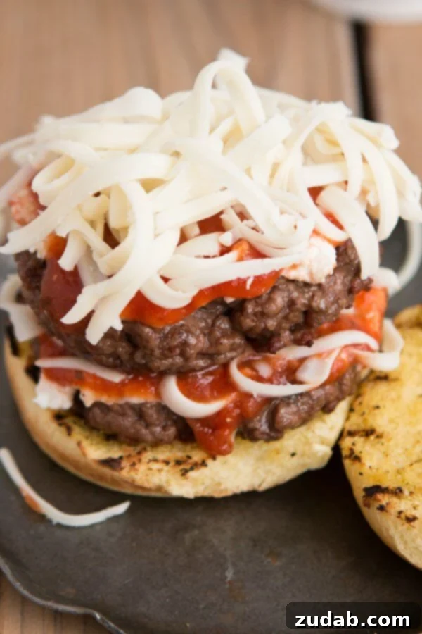 Ricotta, sauce, and mozzarella layered on italian beef for Lasagna burgers! Bring on summer! ohsweetbasil.com Delectable lasagna burger featuring seasoned ground beef, rich ricotta, savory marinara, and melted mozzarella, served on toasted garlic bread buns.