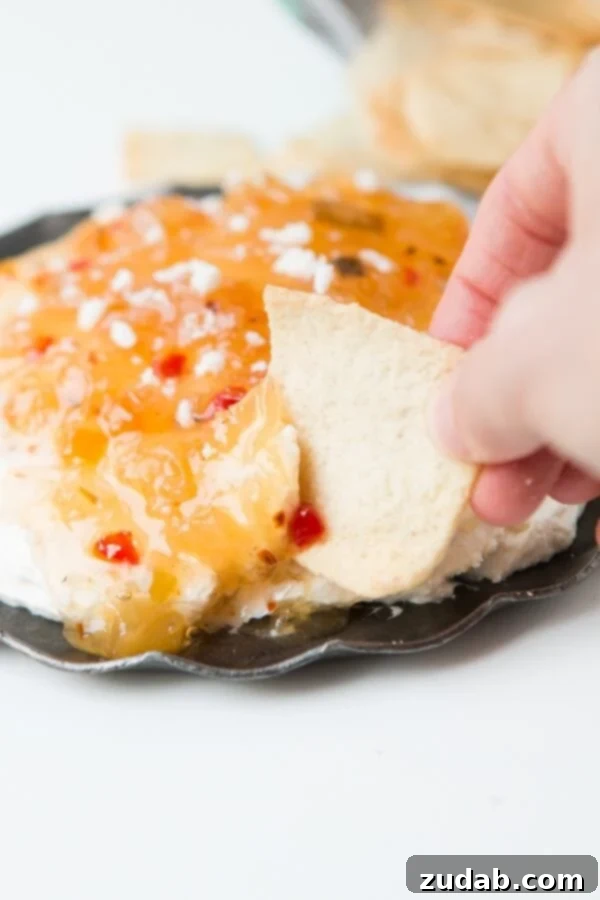 Irresistible Pineapple Habanero Dip - A Spicy Sweet Appetizer Close-up of a bowl of creamy pineapple habanero dip garnished with extra cheese.