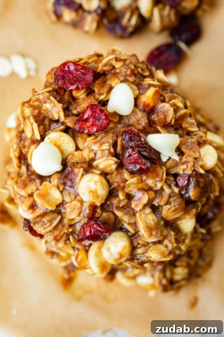 Spiced White Chocolate Cranberry Breakfast Cookies 4 A mouth-watering image of baked oatmeal breakfast cookies, generously studded with vibrant craisins and sweet white chocolate chips.