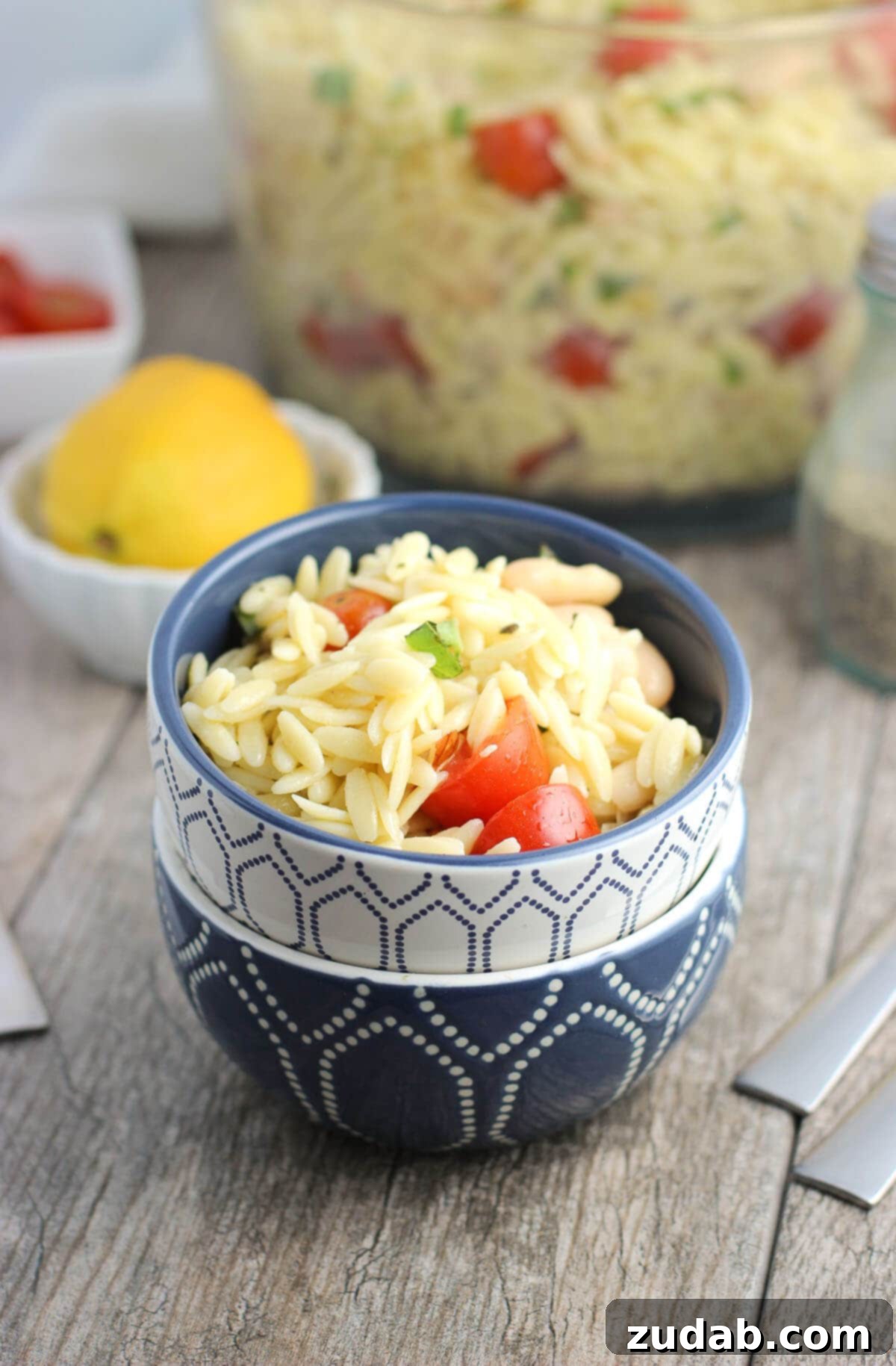 Fresh Lemon Orzo Pasta Salad for warm weather enjoyment Close-up of refreshing Lemon Orzo Pasta Salad, showcasing the texture and vibrant fresh ingredients like basil and tomatoes.