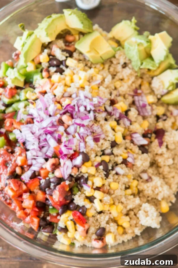 Fresh Ingredients for Cowboy Caviar Quinoa A beautiful array of fresh ingredients for Cowboy Caviar Quinoa, including colorful bell peppers, corn, and avocado, ready to be tossed in a Bertolli olive oil dressing.