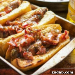 Honey Mustard Bacon Brats 7 A close-up shot of grilled Honey Mustard Bacon Brats on toasted buns, drizzled with sauce.