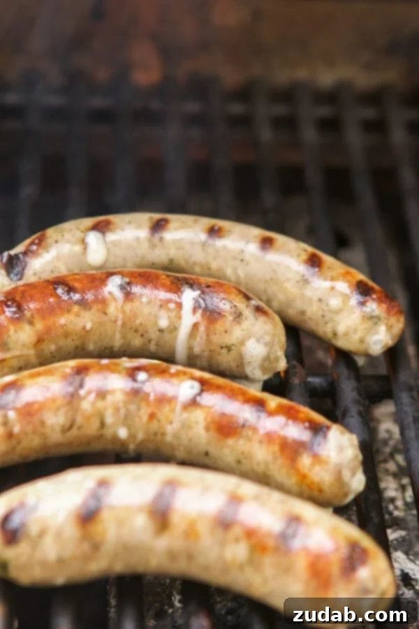 Honey Mustard Bacon Brats 4 Hands preparing brats on a hot grill, brushing with Bertolli Pure Olive Oil for a perfect sear.