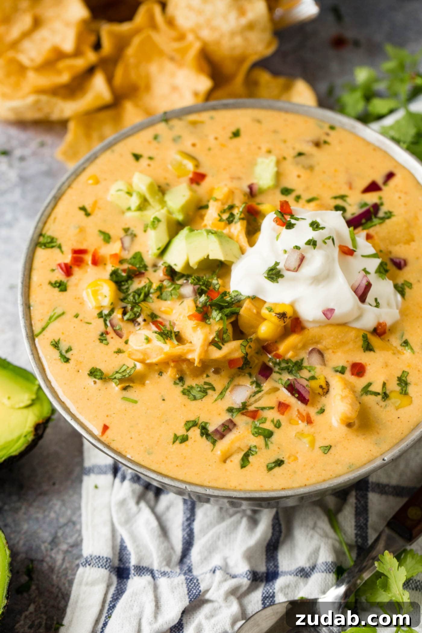 Hearty Cheesy Southwestern Chicken Tortilla Soup 9 A delicious bowl of Cheesy Southwest Chicken Soup, beautifully garnished with sour cream and fresh avocado.