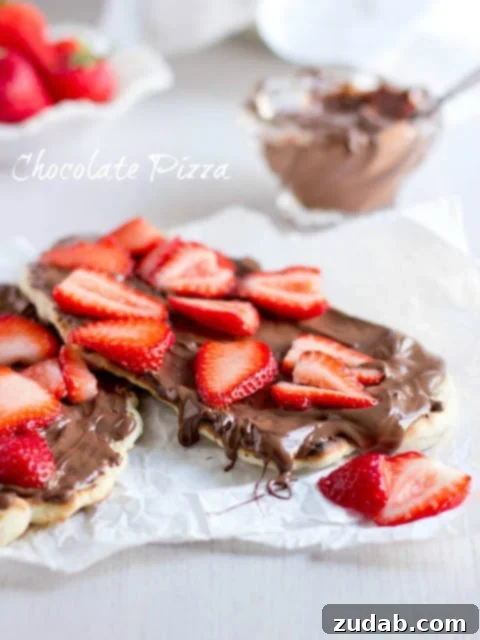 Nutella Strawberry Delight Pizza 2 Delicious grilled Naan bread topped with melted Nutella and fresh sliced strawberries, ready to serve.