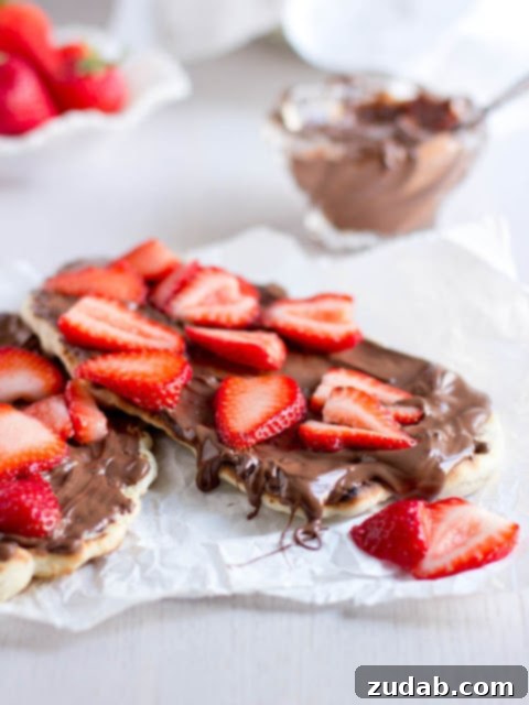 Nutella Strawberry Delight Pizza 5 Overhead shot of the grilled Naan dessert pizza, showcasing the generous spread of Nutella and vibrant fresh strawberries.