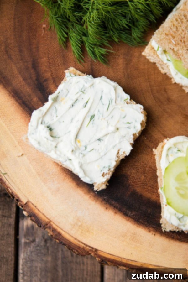 The best lemon dill cucumber sandwiches I've ever had added a touch of Greek yogurt to the spread. Try this awesome tea sandwich recipe at your next party with eureka!® Organic Bread! cucumber sandwiches with cream cheese being assembled