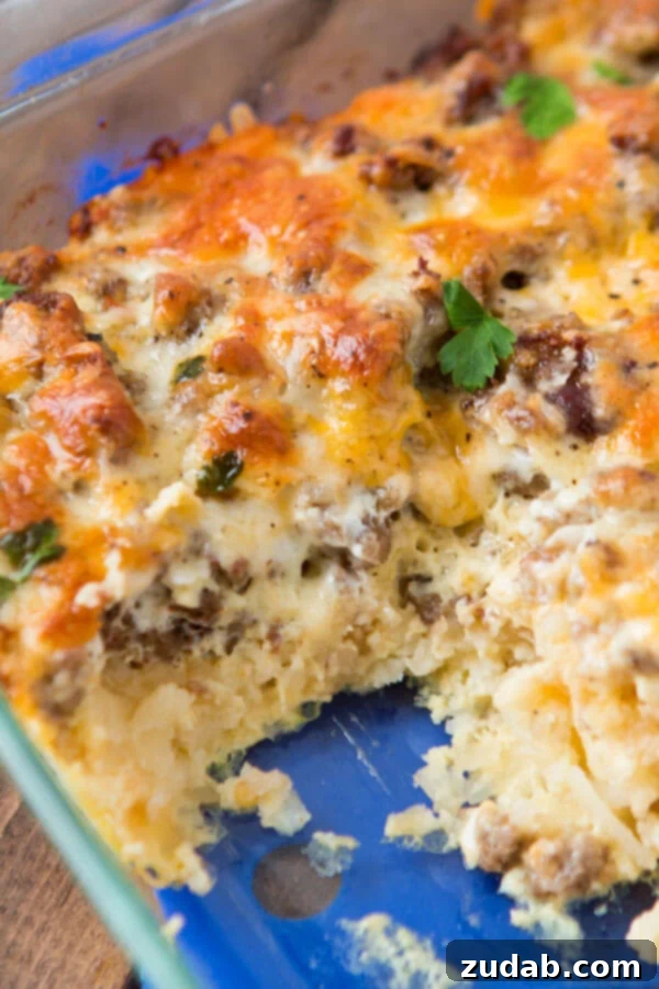 Delicious cheesy hash brown sausage breakfast casserole in a clear glass baking dish, fresh from the oven and ready to serve. Delicious cheesy hash brown sausage breakfast casserole in a clear glass baking dish, fresh from the oven and ready to serve.