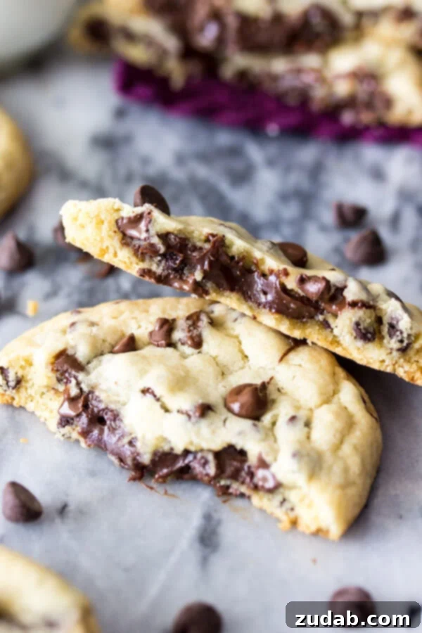 Decadent Fudge Filled Chocolate Chip Cookies: A Surprising Treat! A golden-baked fudge filled chocolate chip cookie broken in half, revealing the soft, gooey chocolate fudge filling inside.