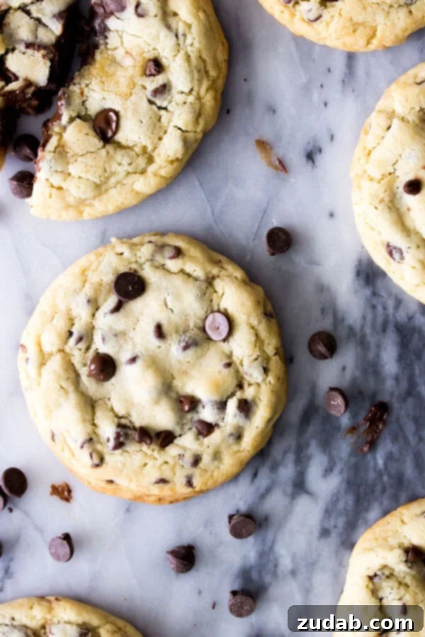 The Gooey Center of Perfection: Fudge-Filled Cookies An overhead shot of several golden-baked fudge filled chocolate chip cookies, with one cracked open to reveal the warm, oozing fudge filling.