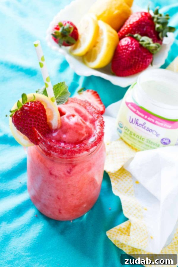 Enjoying the Smooth Texture of Homemade Frozen Strawberry Lemonade A person pouring the freshly blended Frozen Strawberry Lemonade into a glass, showcasing its thick, creamy texture and vibrant color.