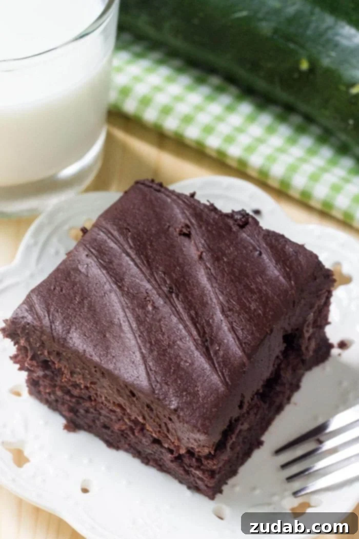 Decadent Double Chocolate Zucchini Cake 3 overhead view of chocolate zucchini cake slice on white plate with glass of milk