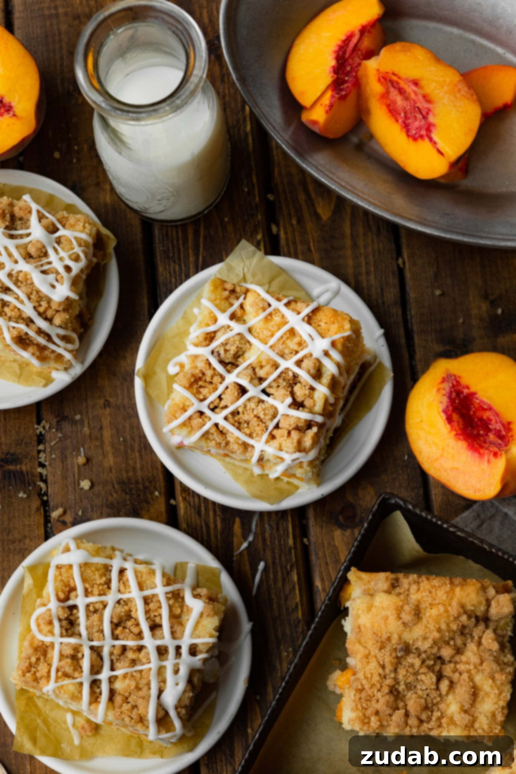 Peach Streusel Coffee Cake 3 a photo taken above several small dessert plates of peach coffee cake topped with a cinnamon streusel topping and white glaze drizzle.