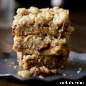 You will fall in love with these #Reeses Crumble bars. Buttery oatmeal cumble stuffed with chocolate chips and #Reesespeanutbuttercups ohsweetbasil.com_