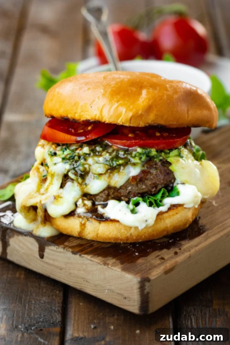 Aromatic Caprese Pesto Burgers 2 A perfectly cooked garlic pesto caprese burger, topped with creamy melted Havarti cheese, vibrant pesto, and bright red tomatoes, all served on a golden toasted brioche bun. This image captures the essence of a gourmet burger ready for a summer feast.