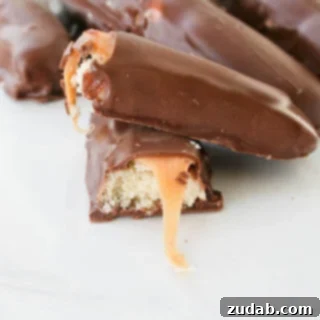 Delicious Homemade Twix Candy Bars, featuring a crisp shortbread base, chewy caramel, and smooth chocolate coating.