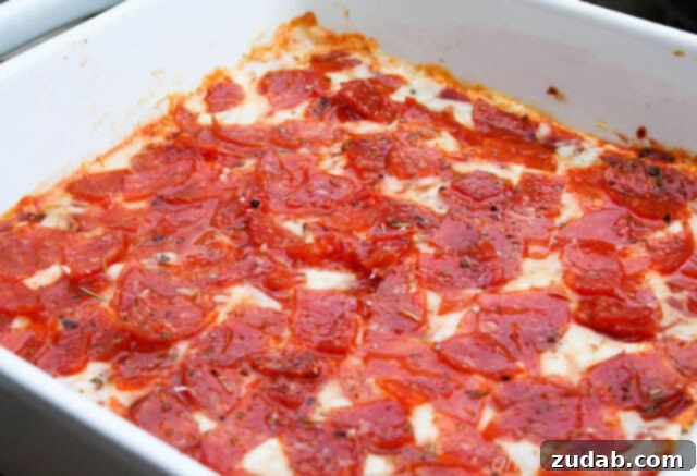 Ultimate Pepperoni Pizza Dip 2 white baking dish filled with pepperoni pizza dip