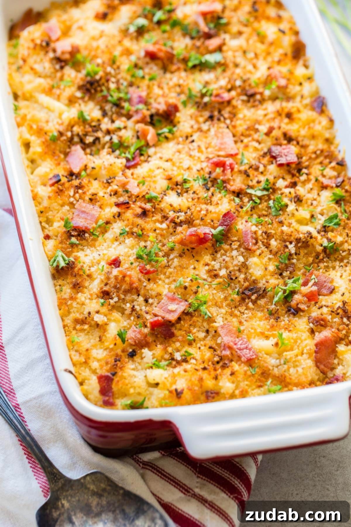 Loaded Chicken Bacon Ranch Mac and Cheese 2 pan of chicken mac and cheese bake on a tea towel, showcasing a golden crispy topping and rich, creamy sauce