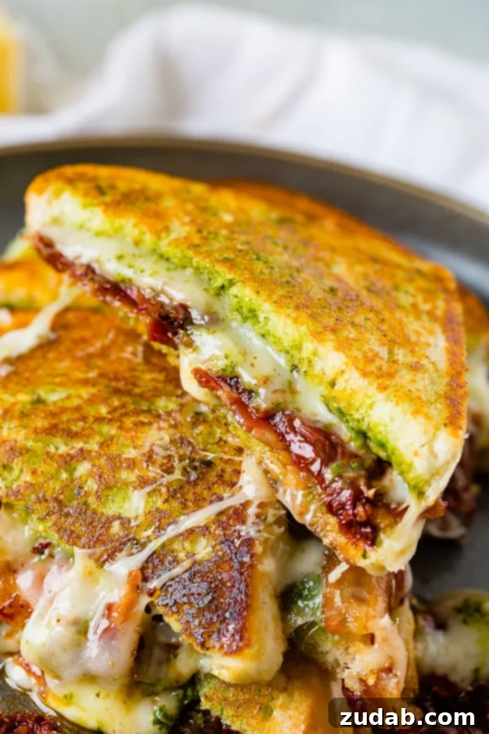 Mediterranean Bacon Pesto Grilled Cheese 9 Another view of a Sun Dried Tomato Bacon Pesto Grilled Cheese sandwich, cut in half and stacked